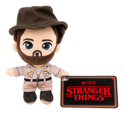 Plush toy with a hat and outfit, next to a 'Stranger Things' tablet case on a white background