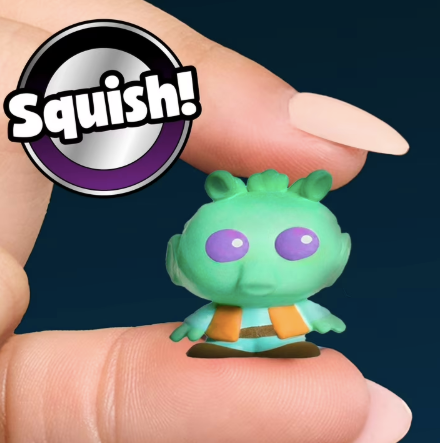 Green squishy toy held between fingers with 'Squish!' logo in the corner