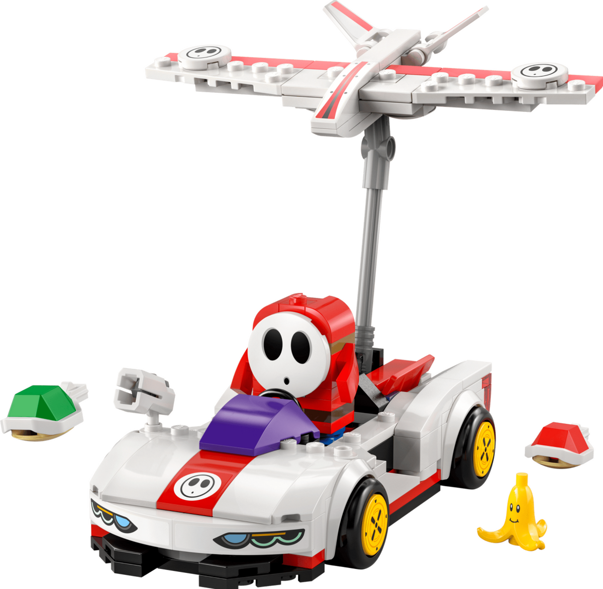 A LEGO-style toy vehicle set featuring a white race car with red and purple details, a gray support pole, a white and red airplane mounted on top, a small yellow banana-shaped figure, and two small accessory pieces on a plain white background.