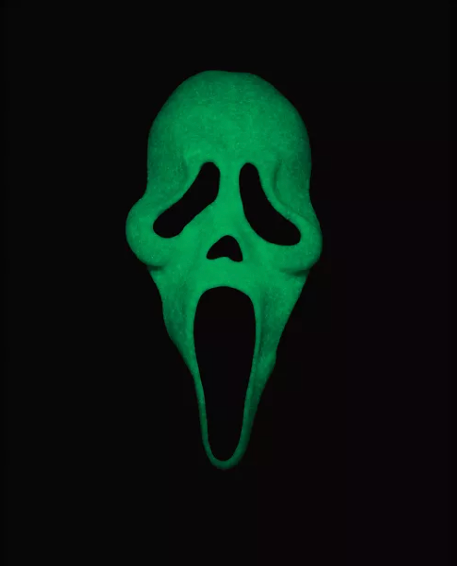 A green glow-in-the-dark Ghostface mask centered on a solid black background.