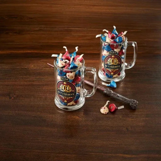 Two glass mugs filled with colorful candy on a wooden surface