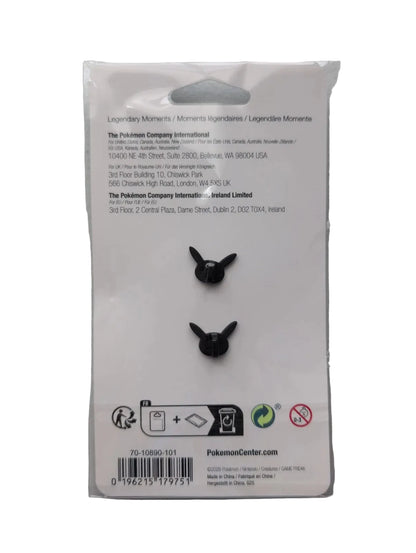 Packaged black rubber Pokémon Charizard egg-shaped charms on a white backing card inside a clear plastic sleeve, photographed against a light gray wall.