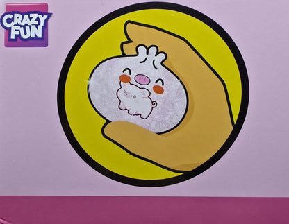 A sticker or decal featuring a cute cartoon character, shown applied to a pink surface. The sticker depicts a small white character with pink cheeks and a pink nose, nestled inside a yellow circle with a black border, held by a tan hand.