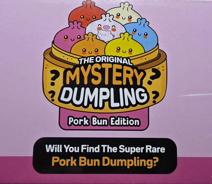 Front of a product box or package for a mystery dumpling set, featuring cartoon dumplings in a steamer basket with the text 'The Original Mystery Dumpling' and 'Pork Bun Edition.' A black banner at the bottom reads, 'Will You Find The Super Rare Pork Bun Dumpling?' The background is a pink-lavender gradient.