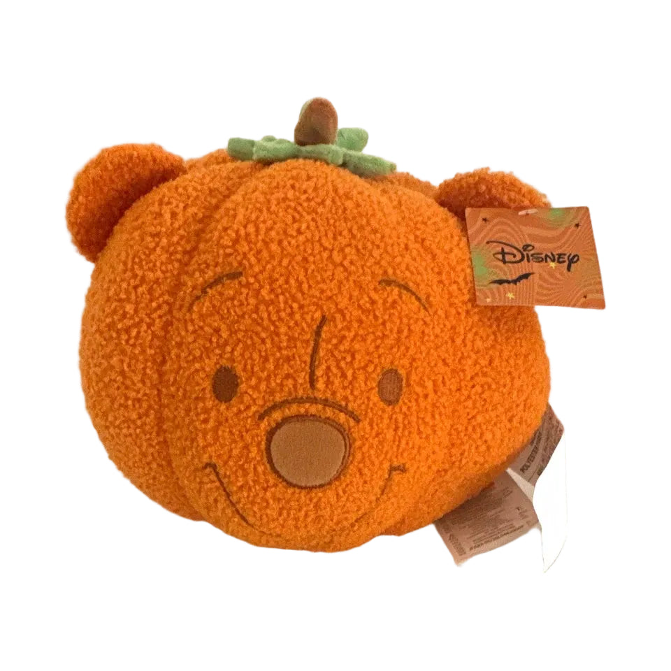An orange plush pumpkin bear toy with a green stem and a Disney tag attached, photographed on a plain white background.