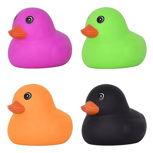Squishy duck toys arranged in a 2x2 grid on a white background, each in a different body color: pink, green, orange, and black, with orange beaks.
